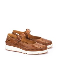 Bottines Mary Jane en cuir de couleur beige avec un design perforé, bride de cheville ajustable et semelle en caoutchouc blanc avec une texture subtile.