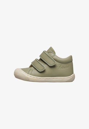 Chaussure en cuir vert avec deux bandes Velcro, bout rond et semelle en caoutchouc, présentant une semelle extérieure texturée blanc cassé et un logo sur le côté.