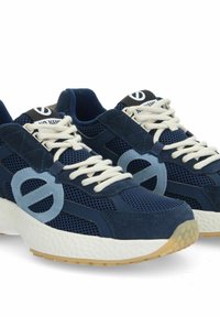 Blaue Sportschuhe aus Mesh und Wildleder, mit einem runden Logo-Akzent und einer massiven weißen Sohle mit strukturierter Oberfläche.