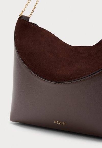 Καφέ δερμάτινη και σουέτ τσάντα ώμου με χρυσή αλυσίδα και το λογότυπο "NEOUS" σε χρυσά γράμματα στο μπροστινό μέρος.