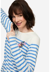 Długi rękaw w pasy w kolorze białym i niebieskim, z kolorową grafiką ryby na klatce piersiowej. Miękki materiał o luźnym kroju i okrągłym dekolcie.