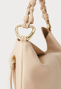 Helle beigem Lederhandtasche mit geflochtenem Griff und goldfarbenen Beschlägen. Seitlicher Reißverschluss sorgt für Funktionalität. Glatte Textur mit strukturierter Form.