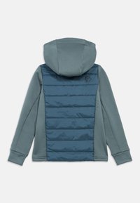 Hooded jaka ar mīkstu pelēki zaļu priekšpusi un tumši zilu, izšuvumu aizmugures paneli. Ievērojams ģeometrisks logo augšējā aizmugurē.
