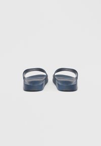 Tamsiai mėlynos šlepetės su lygiu paviršiumi, atvira nosimi ir minimalistiniu dizainu. Turi plokščią, ergonomišką padą komfortui užtikrinti.