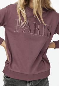 Lila Sweatshirt mit eingeprägtem "PARIS"-Text. Merkmale sind ein Rundhalsausschnitt, Bündchen und Saum aus Rippstrick. Weicher Stoff mit lässiger Passform.