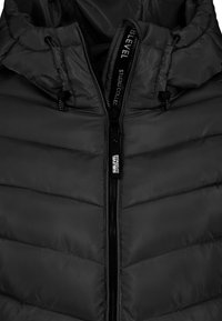 Dunkle gepolsterte Jacke mit Kapuze, ausgestattet mit einem Reißverschluss und kontrastierenden Nähten. Hergestellt aus glattem Stoff mit einem strukturierten Muster.