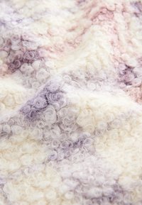 Blødt, krøllet tekstureret stof med et gradientmønster i creme, lavendel og lyserøde nuancer, vist i nærbillede.