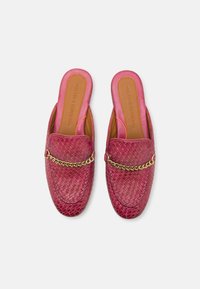 Zapatos slip-on de cuero trenzado en color rosa con un acento de cadena dorada en la parte superior. Forro interior suave con el logo de la marca grabado en la plantilla.