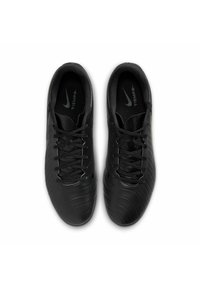 Black soccer shoes with a textured surface, lace-up design, and a padded collar. Features a subtle Nike logo on the side.