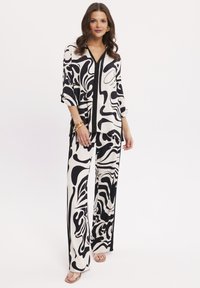 Czarnobiałe, wzorzyste dwuczęściowe zestawienie składające się z luźnej koszuli z rękawem do trzech czwartych oraz spodni z szerokimi nogawkami.