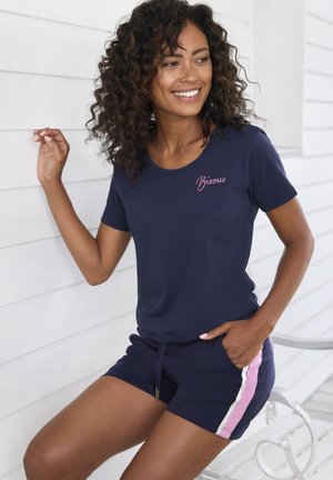 Navy short-sleeve top with "Bisous" embroidery and navy shorts featuring pink and white side stripes. Soft fabric, relaxed fit.