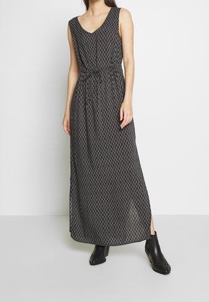 Maxi sukienka w czarnym kolorze z geometrycznym wzorem, dekoltem w serek, ściągaczem w talii i bocznym rozcięciem. Noszona z czarnymi botkami za kostkę. Gładka tekstura.