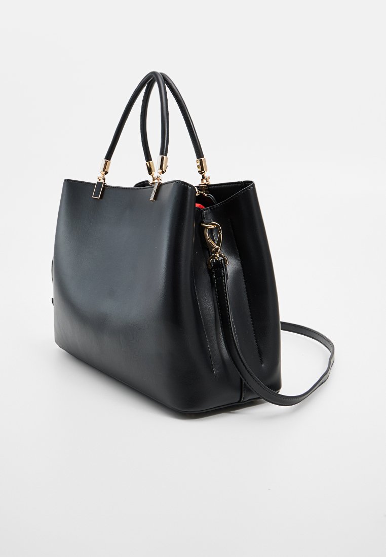 Borsa a tracolla in pelle nera con doppio manico superiore, tracolla rimovibile e ferramenta in metallo dorato, su uno sfondo chiaro uniforme.