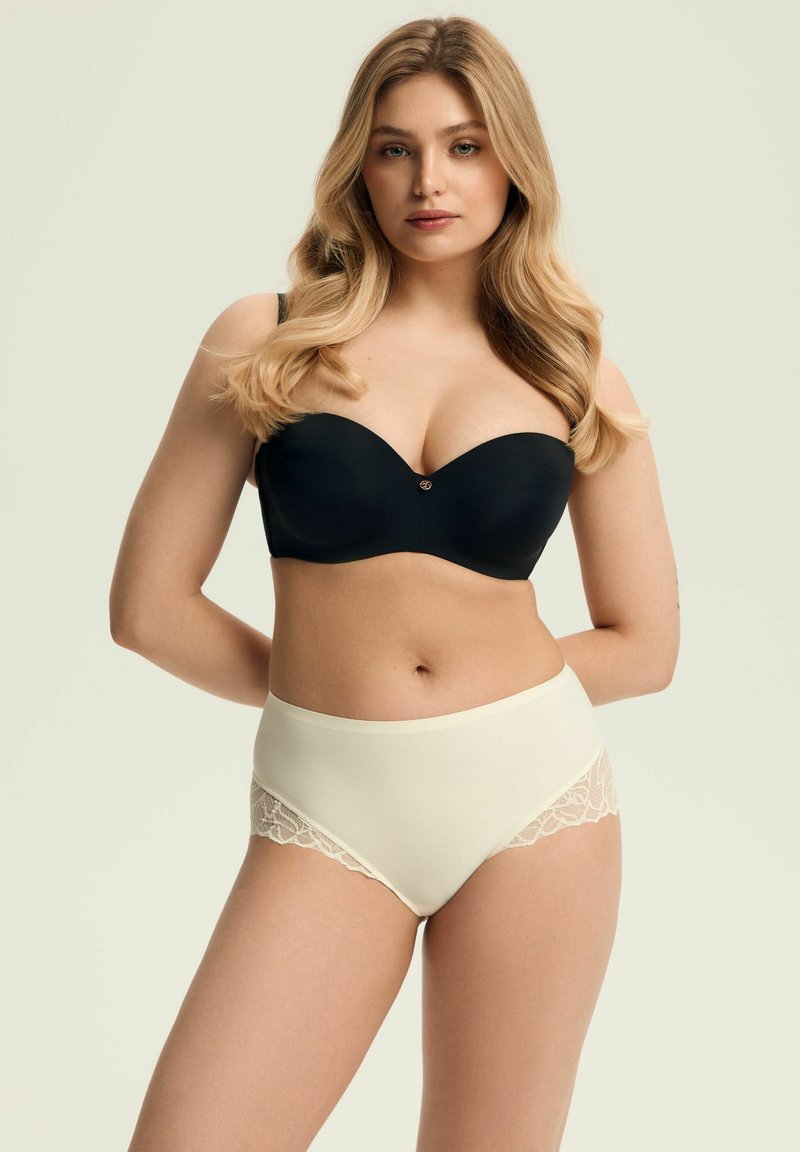 Czarny gładki stanik bez ramiączek z ozdobnym guzikiem, w połączeniu z wysokim, kremowym majtkami z koronkowymi akcentami po bokach.