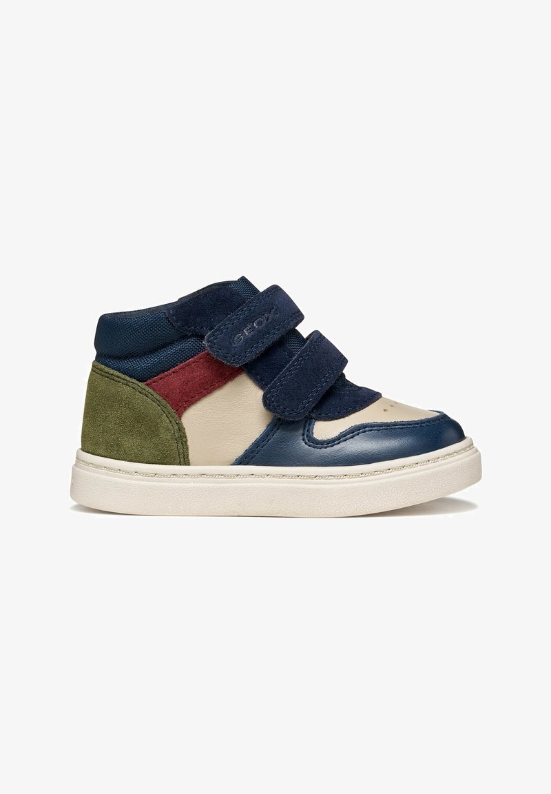 Baskets montantes pour enfant avec des panneaux bleu marine, beige, rouge et vert, deux bandes velcro bleu marine et une semelle blanche.