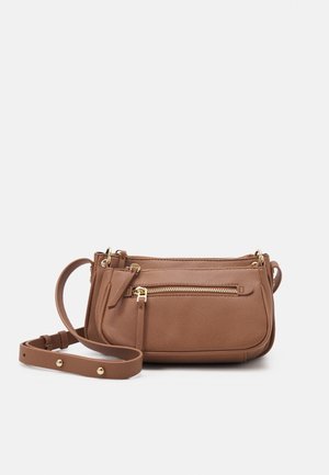 Bruine leren crossbodytas met gouden ritsen en verstelbare riem tegen een effen achtergrond.