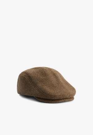 Gorra plana marrón texturizada con líneas de costura visibles, mostrada en ángulo sobre un fondo blanco.