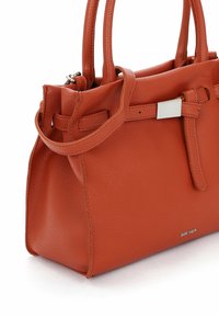 Orange läderhandväska med strukturerad yta, utrustad med dubbla handtag, en bälteaccent och detaljer i silverfärgad metall.