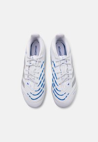 Scarpe sportive bianche con accenti blu, motivo testurizzato, sistema di allacciatura e sottili strisce argentate sui lati. Marchio in evidenza sulle linguette.