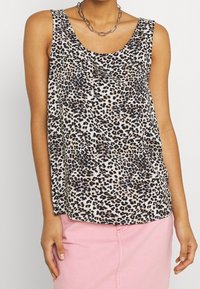 Leopardmönstrad ärmlös topp i lätt tyg, med rundad halsringning och lös passform, kombinerad med en rosa underdel.