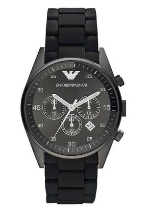 Black chronograph watch with a textured rubber band and a dark dial featuring three sub-dials and a date display at 4 o'clock. Silver accents.