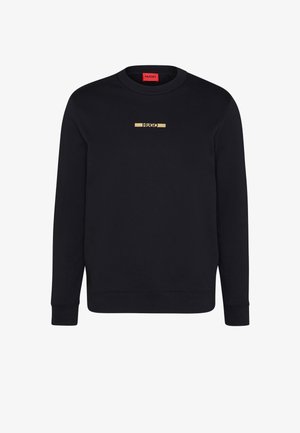Sweat-shirt noir à manches longues et col rond avec logo "HUGO" doré centré sur la poitrine et étiquette rouge à l'intérieur du col.