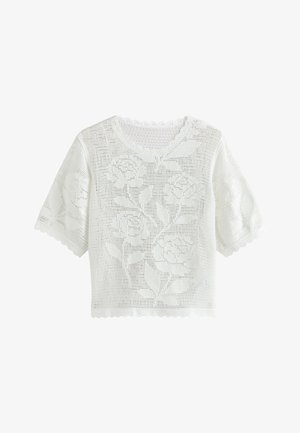 Haut blanc en crochet à manches courtes avec motifs floraux, bords festonnés aux manches, à l'encolure et à l'ourlet.