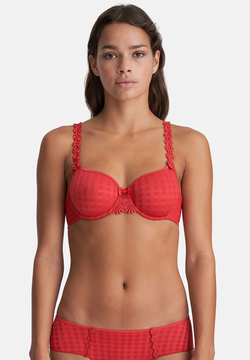 Red bra with textured, checkered pattern, lace accents on straps, and a decorative bow at the center. Matching bottoms visible below.