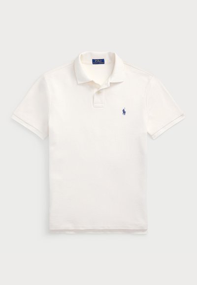 Koszulka polo w kolorze ecru z bawełnianego materiału, z klasycznym kołnierzykiem, krótkimi rękawami oraz małym, haftowanym logiem w kolorze granatowym po lewej stronie klatki piersiowej.
