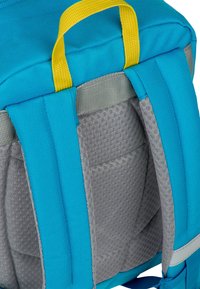 Zaino con un esterno in tessuto blu con accenti grigi, maniglia gialla per il trasporto, spallacci imbottiti e compartimenti in rete.