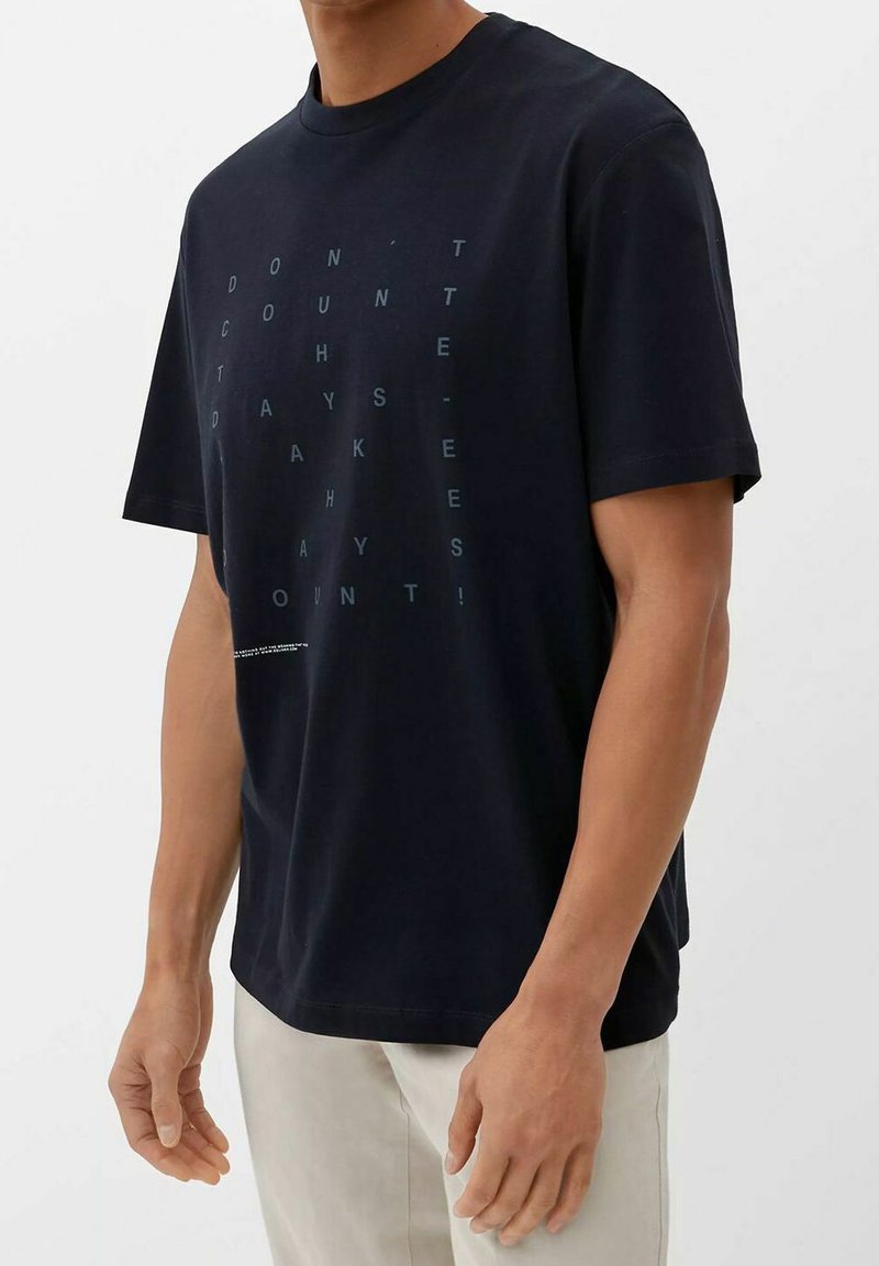 Schwarzes Baumwoll-T-Shirt mit kurzen Ärmeln und Rundhalsausschnitt, versehen mit einem hellblauen Textmuster auf der Vorderseite, das "ZÄHL NICHT DIE TAGE" lautet.