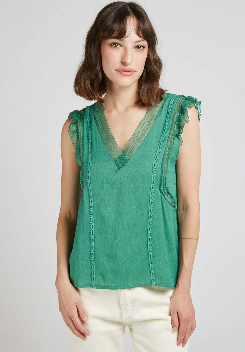 Haut sans manches vert avec un col en V, bord en dentelle aux épaules, détails de couture verticaux et une coupe légèrement ample.