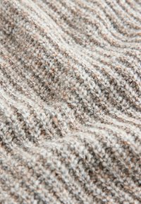 Tessuto testurizzato con sfumature di grigio, beige e bianco, caratterizzato da un motivo a maglia a coste. Morbido e tattile, con un aspetto accogliente.