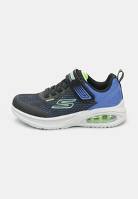 Scarpa sportiva nera e blu con tessuto a rete, colletto imbottito, cinturino regolabile e ammortizzazione verde nella suola.