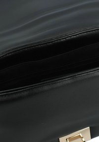 Borsa a tracolla in pelle nera con una texture liscia, dotata di una chiusura in metallo dorato e di un compartimento con zip per un deposito sicuro.