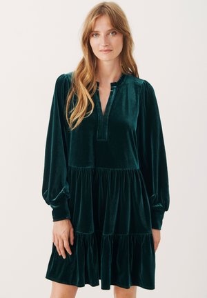 Abito verde in velluto con maniche a sbuffo lunghe, colletto arricciato e gonna a strati. Tessuto liscio e design al ginocchio.