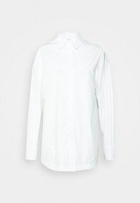 Vit långärmad skjorta med knappar, tillverkad av bomull och med krage. Har tre vertikala ränder på varje arm och en liten logotyp på bröstet.