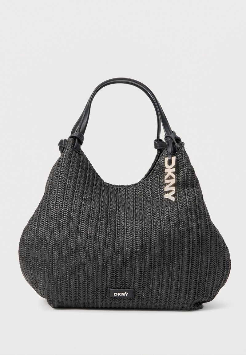 Μαύρη υφαντή τσάντα DKNY με στρογγυλεμένο σχήμα, δύο μαύρες λαβές και ασημένιο λογότυπο DKNY που κρέμεται κοντά στο πάνω μέρος.