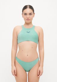 Fényes textúrájú világoszöld bikini szett. A felső magas nyakú, széles pántokkal rendelkezik; az alsó klasszikus bikini szabású.