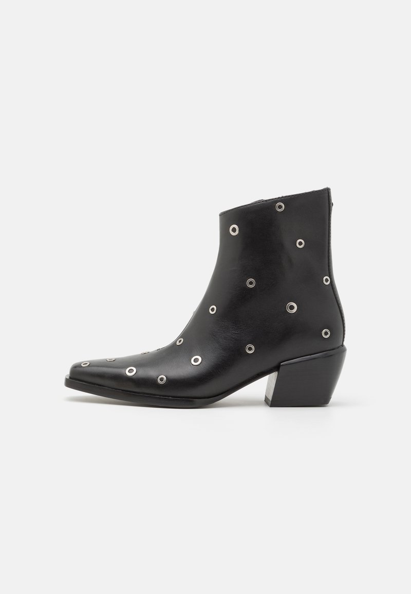 Botă din piele neagră până la glezne cu detalii din ochiuri argintii, vârf ascuțit și toc pătrat. Design elegant cu o textură netedă.