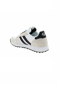 Scarpa atletica leggera con tomaia in mesh bianco, dettagli in suede grigio, strisce nere e suola in gomma texturizzata. Presenta un collare imbottito.