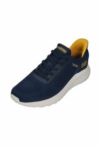 Scarpa da ginnastica della Marina con tomaia in rete traspirante, suola bianca e interno giallo. Presenta un design testurizzato e lacci piatti.