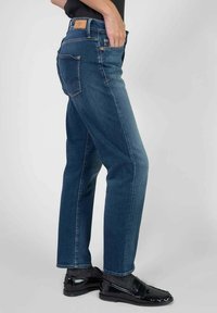 Blauwe denim jeans met een rechte pijpdesign, met een hoge taille, subtiele stiksels en een leren patch op de achterkant van de tailleband.