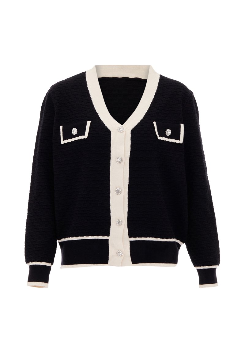 Tummansininen neulejakku, jossa on teksturoitu kudos, vaaleanbeigeet yksityiskohdat, kaksi etutaskua, V-pääntie ja koristeelliset nappi.