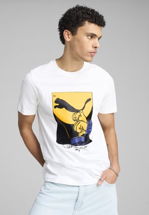 Camiseta blanca de algodón con un diseño gráfico en amarillo, negro y azul de una mano y un pantera. Manga corta, estilo cuello redondo.