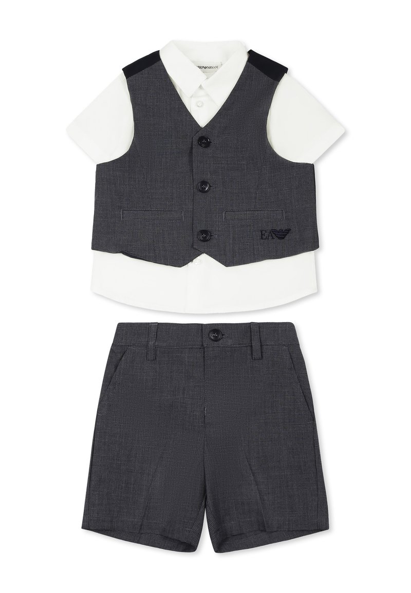 Gilet grigio con due bottoni e tasche laterali, abbinato a una camicia bianca a maniche corte e pantaloni corti grigi, caratterizzati da una sottile texture.
