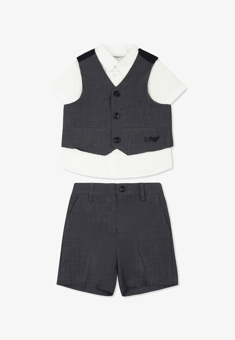 Gilet grigio con due bottoni e tasche laterali, abbinato a una camicia bianca a maniche corte e pantaloni corti grigi, caratterizzati da una sottile texture.