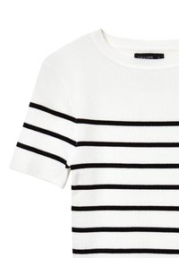 Top bianco a maniche corte con righe orizzontali nere, dotato di scollo rotondo e texture a coste. Etichetta del brand: Calliope.