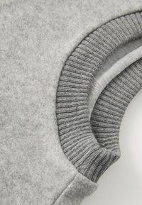 Gray sweatshirt with a soft texture and ribbed cuffs. Features a crew neck and layered gray fabric. Simple, classic design.