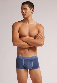 Mörkblå bomullsboxershorts för herr med en tight passform, med en kontrasterande midja som har texten "intimissimi" och en framficka.